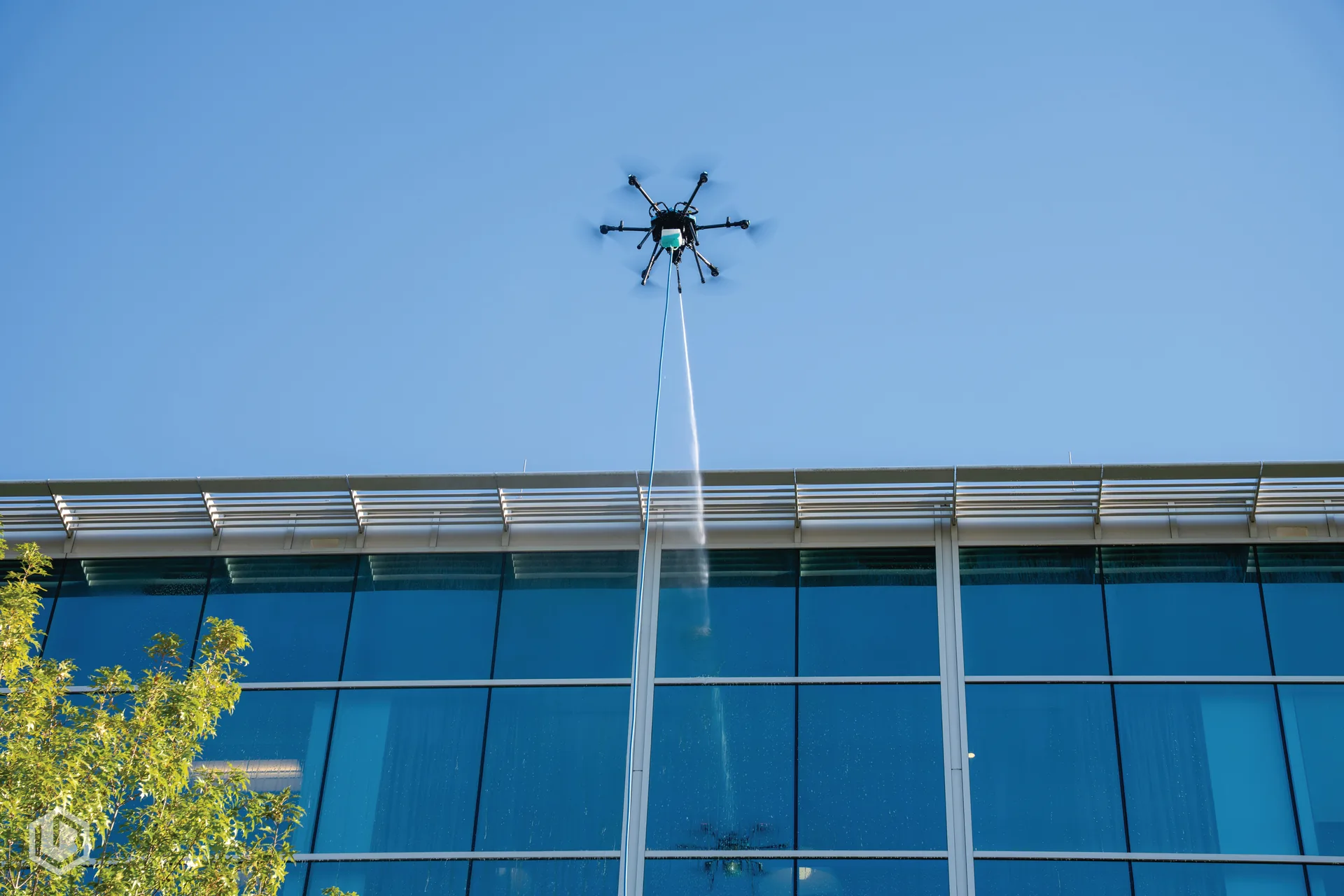 Drone soft washing a building exterior